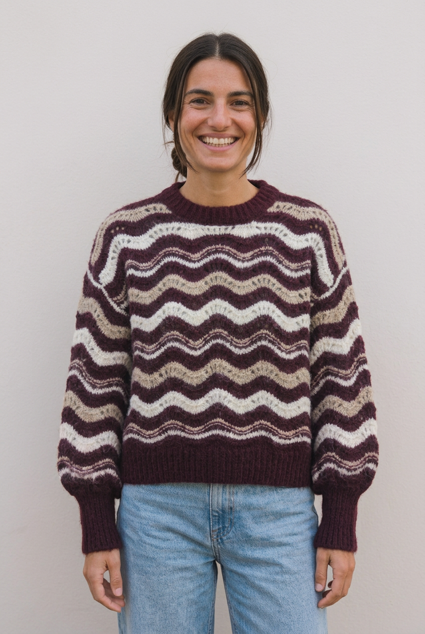 Modelo con jersey Iris granat, moño bajo y sonrisa amplia