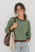 Modelo con jersey verde y marrón chocolate, mismo pantalón y bolso y pañuelo beige